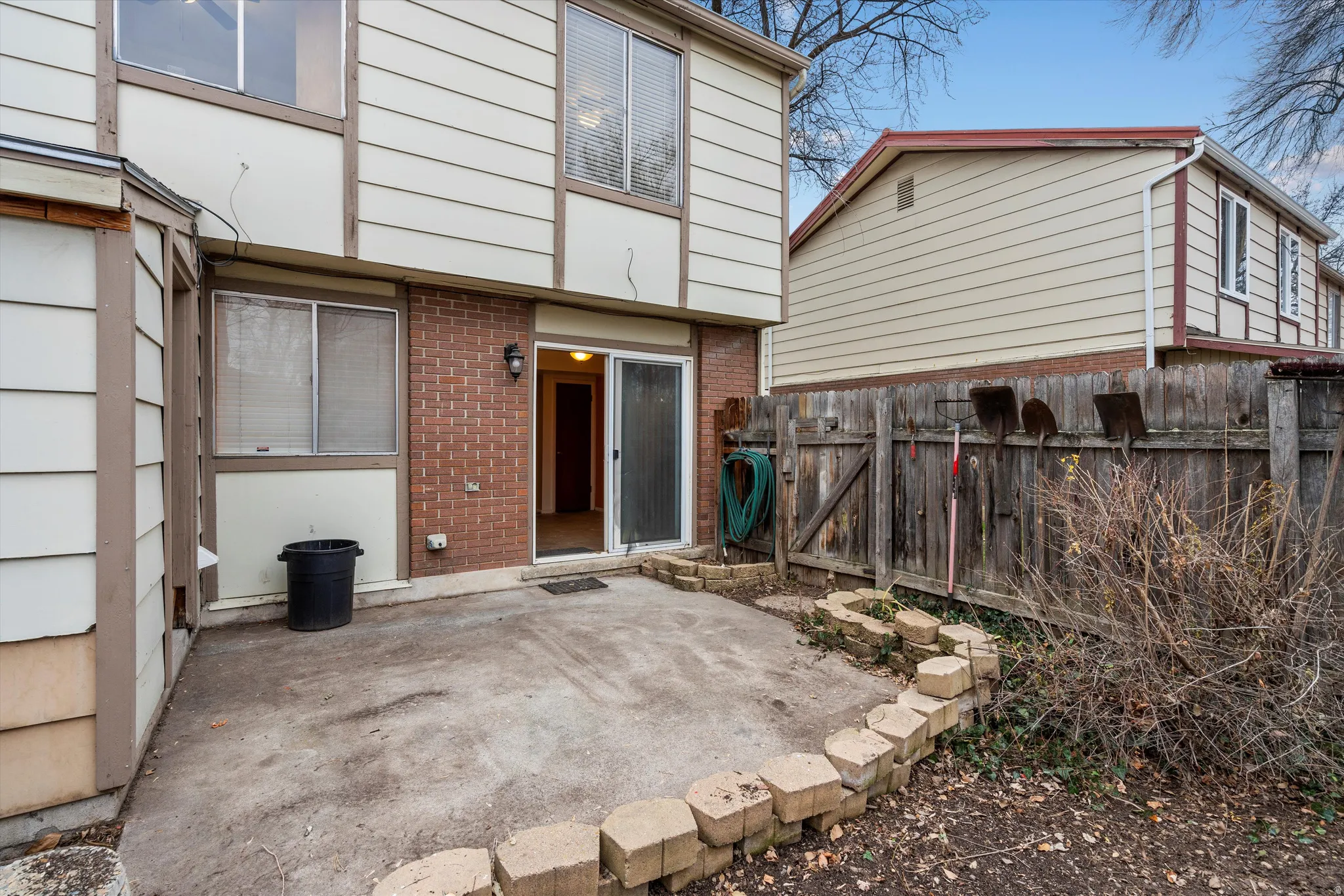 Rear view of house with a patio and brick siding
