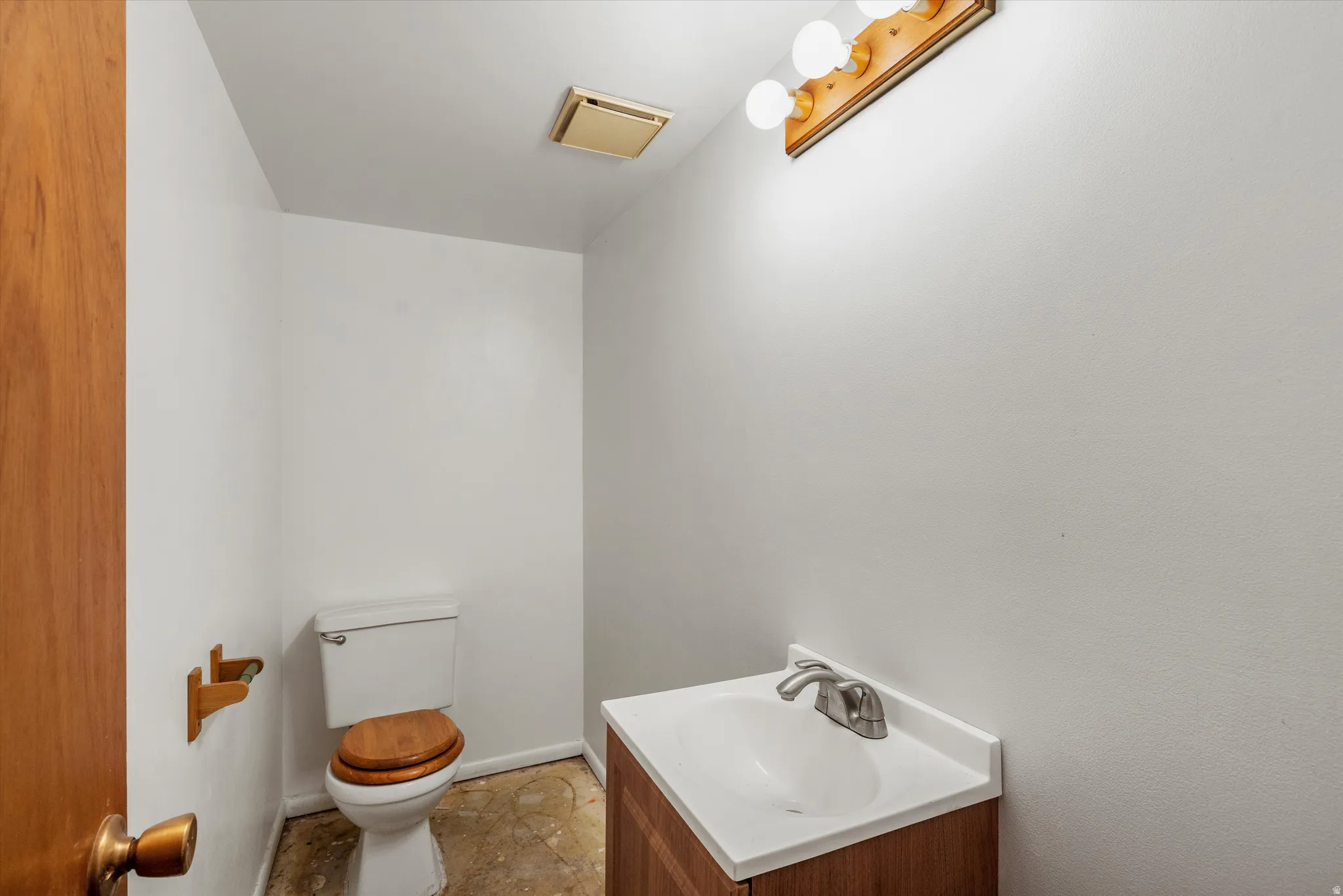 Half bathroom featuring vanity and toilet