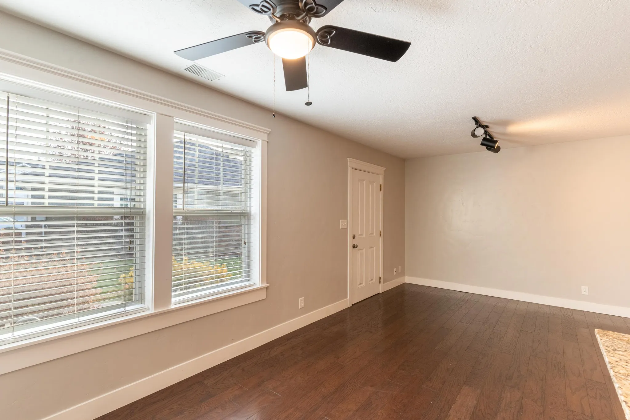 Living  room featuring dark wood finished floors, a textured ceiling, and a ceiling fan