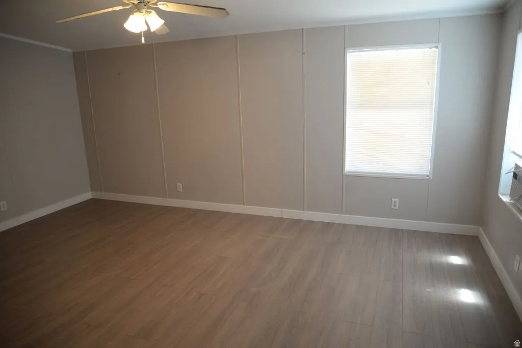 Spare room with wood finished floors and a ceiling fan