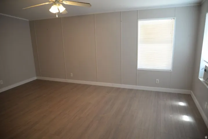 Spare room with wood finished floors and a ceiling fan