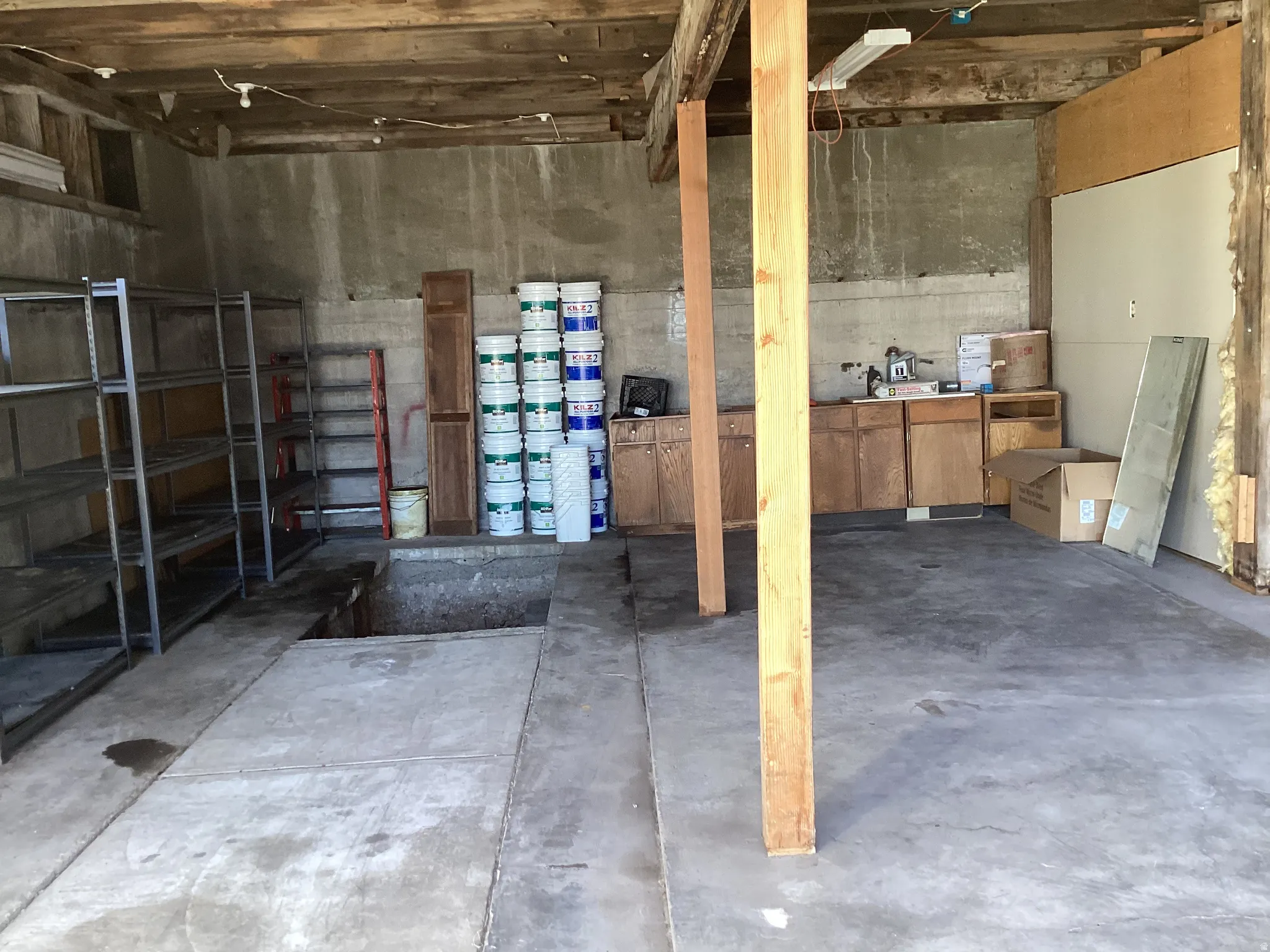 3 car garage with a mechanics pit and a storage room