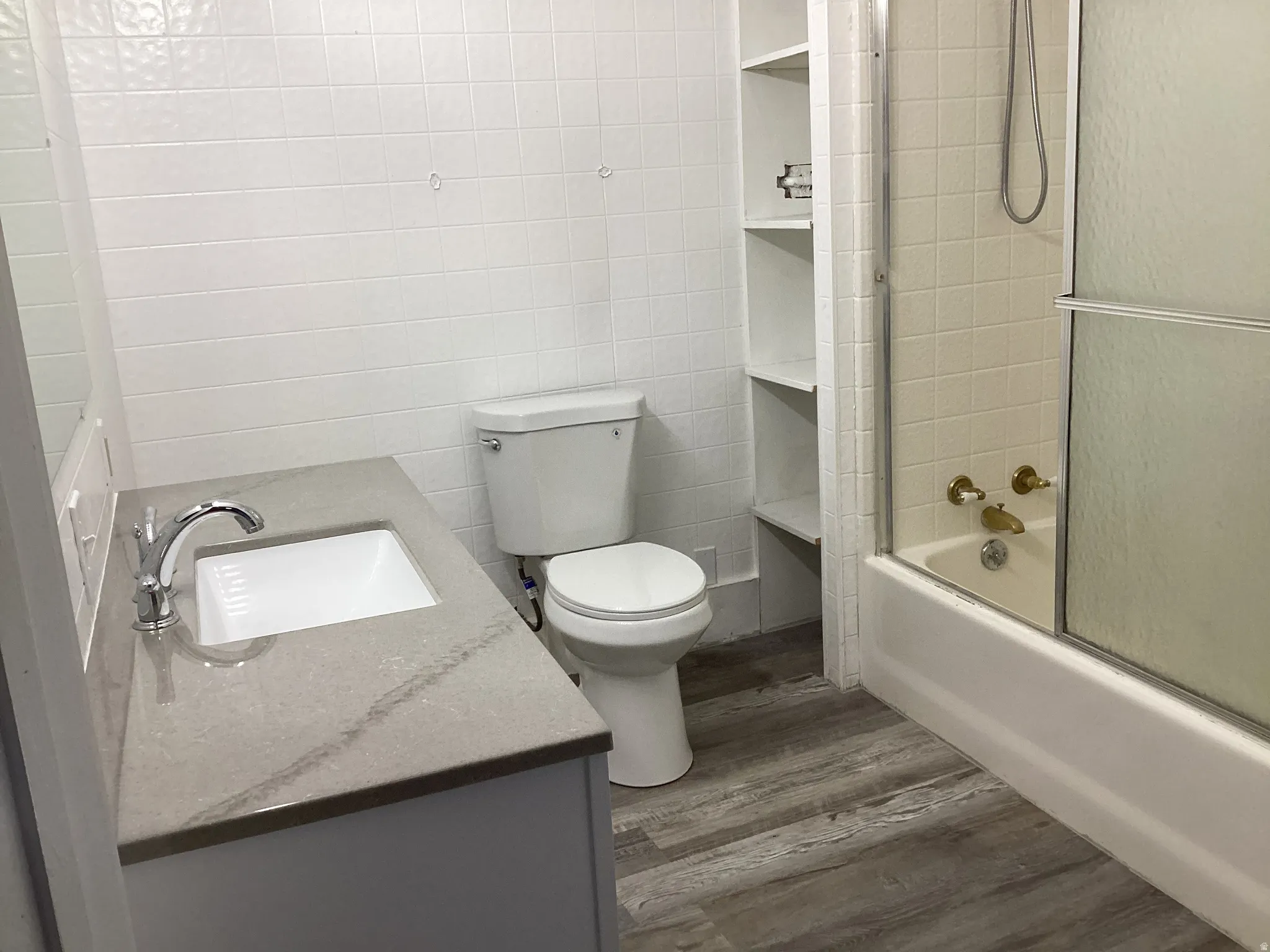 Master Bathroom featuring bath / shower combo with glass door, vanity, and dark wood-type flooring