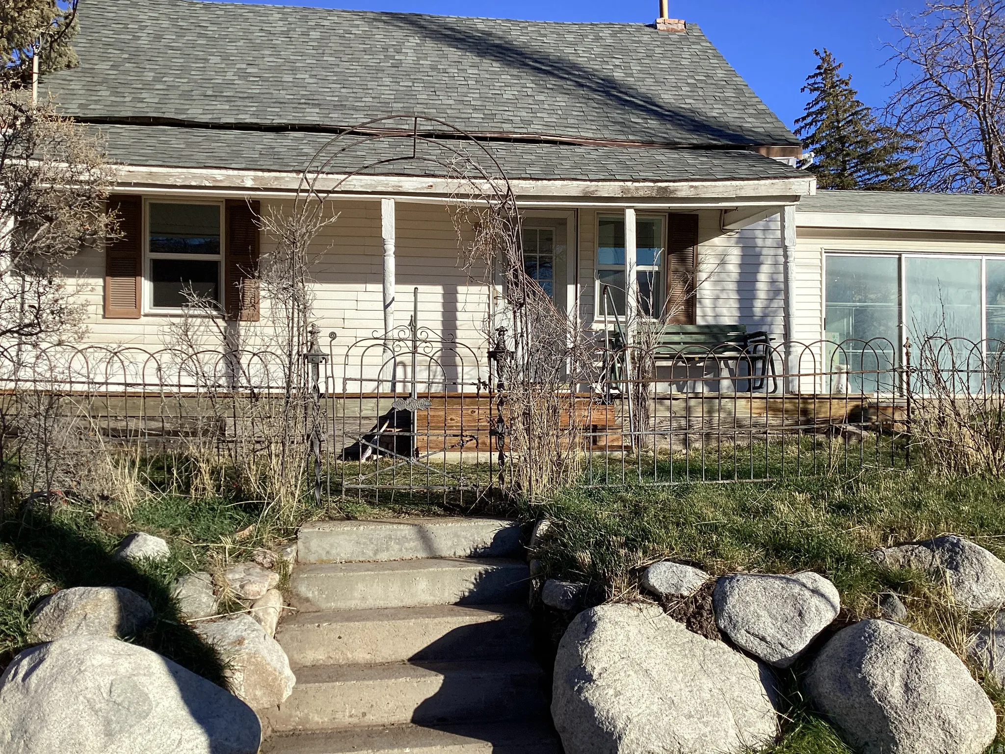 View of front facade featuring a shingled roof and a porch