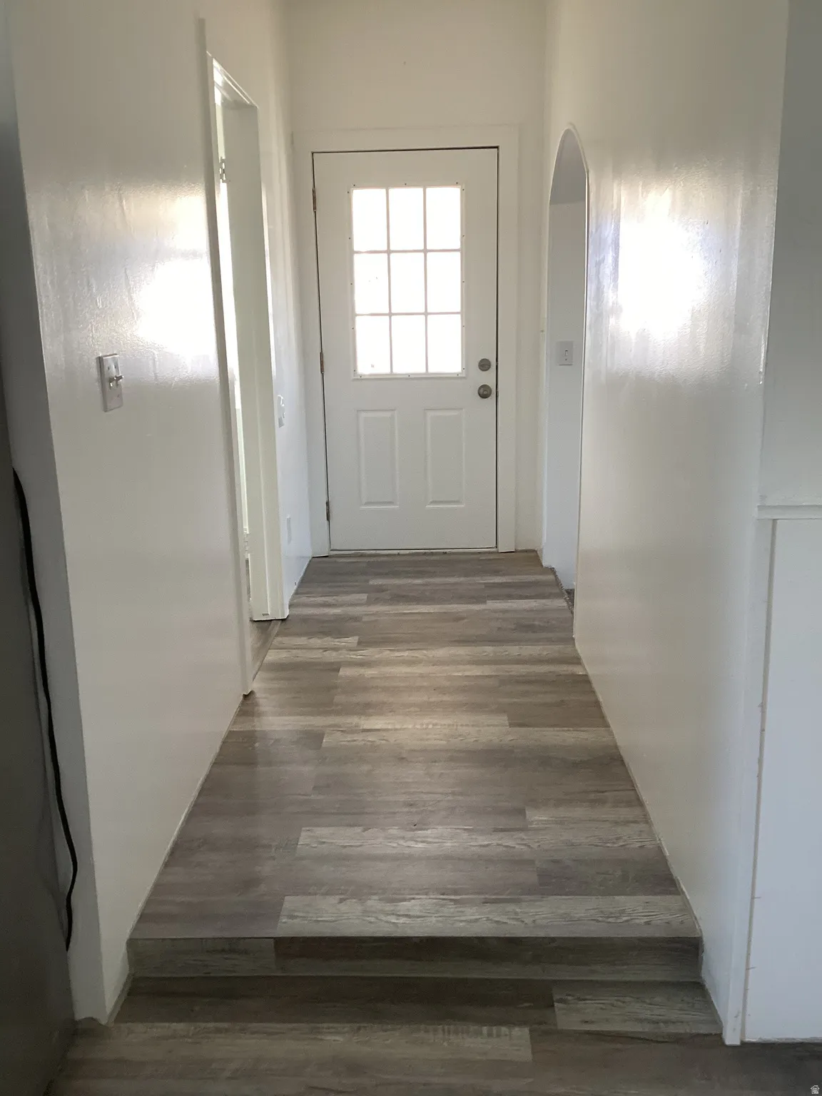 Entryway with wood finished floors and arched walkways