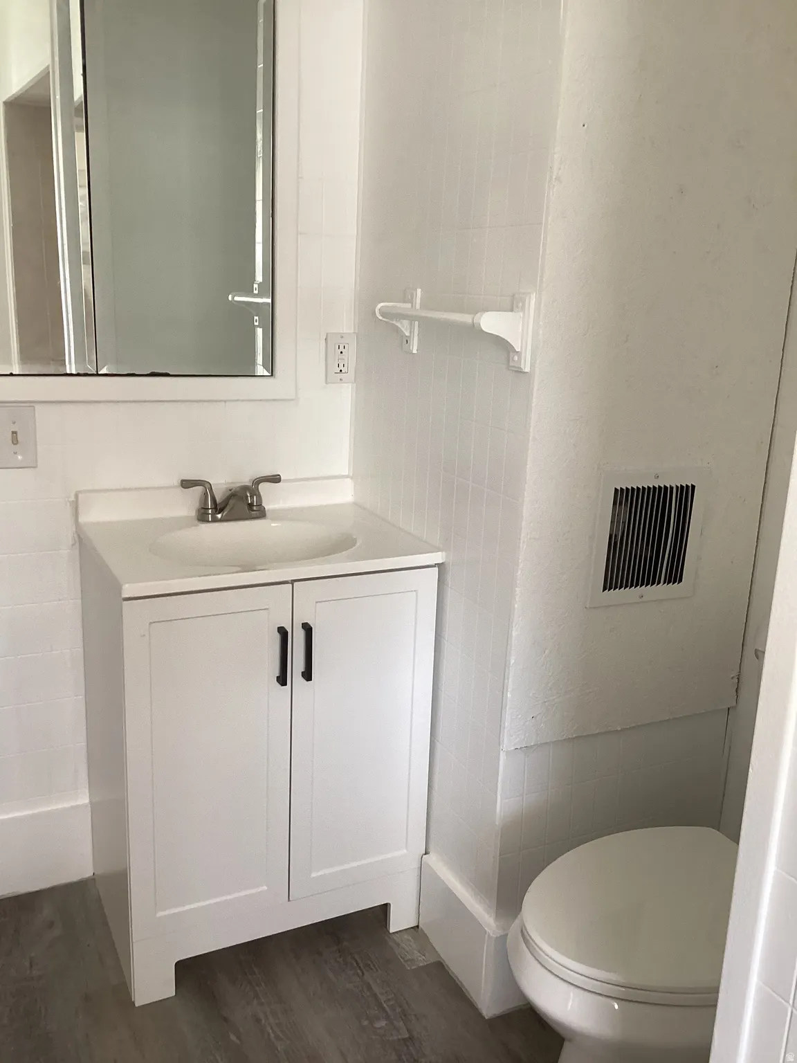 Full bathroom with vanity and dark wood-style flooring
