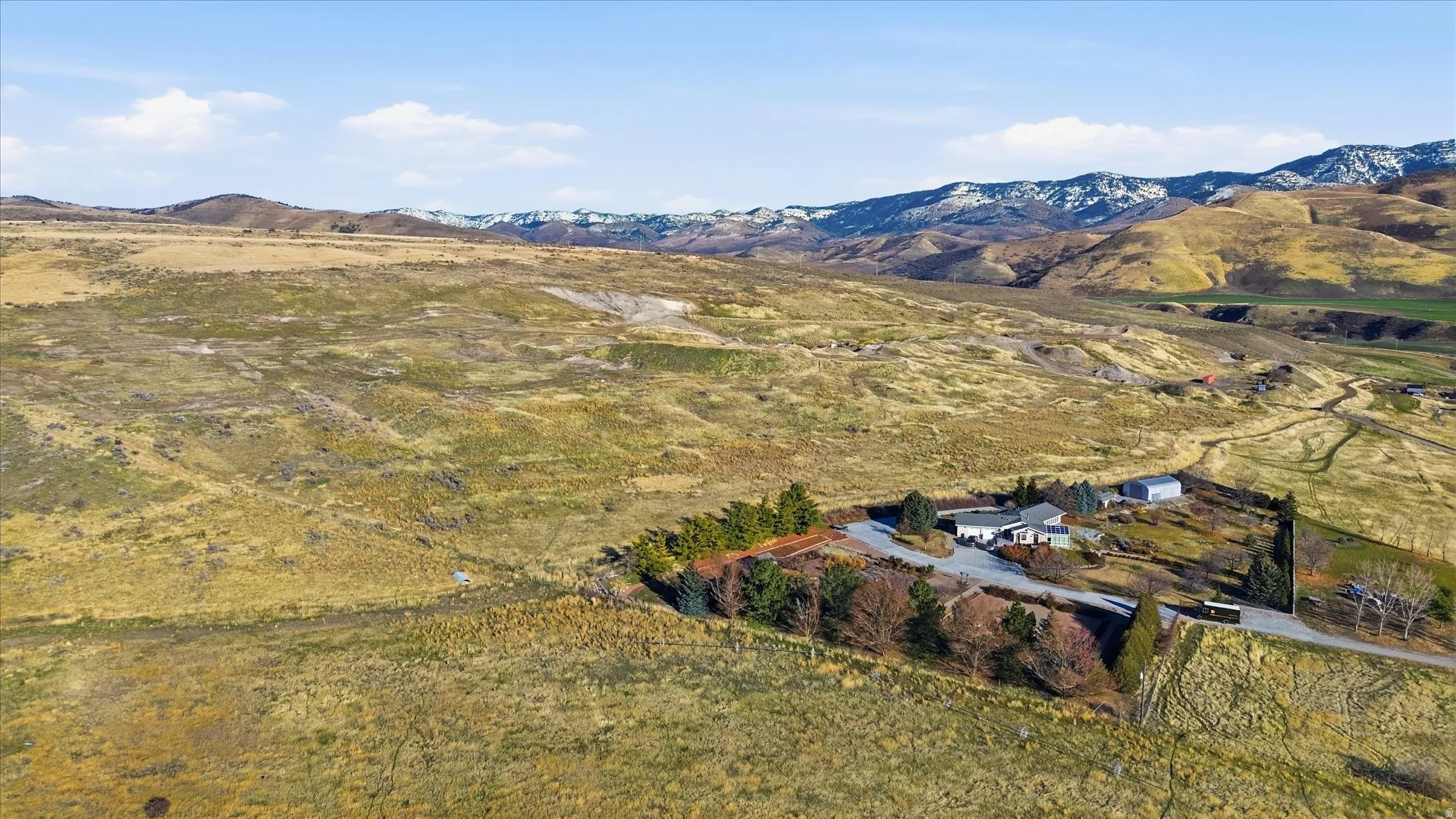 Aerial view of property and surrounding area with a mountainous background and rural landscape