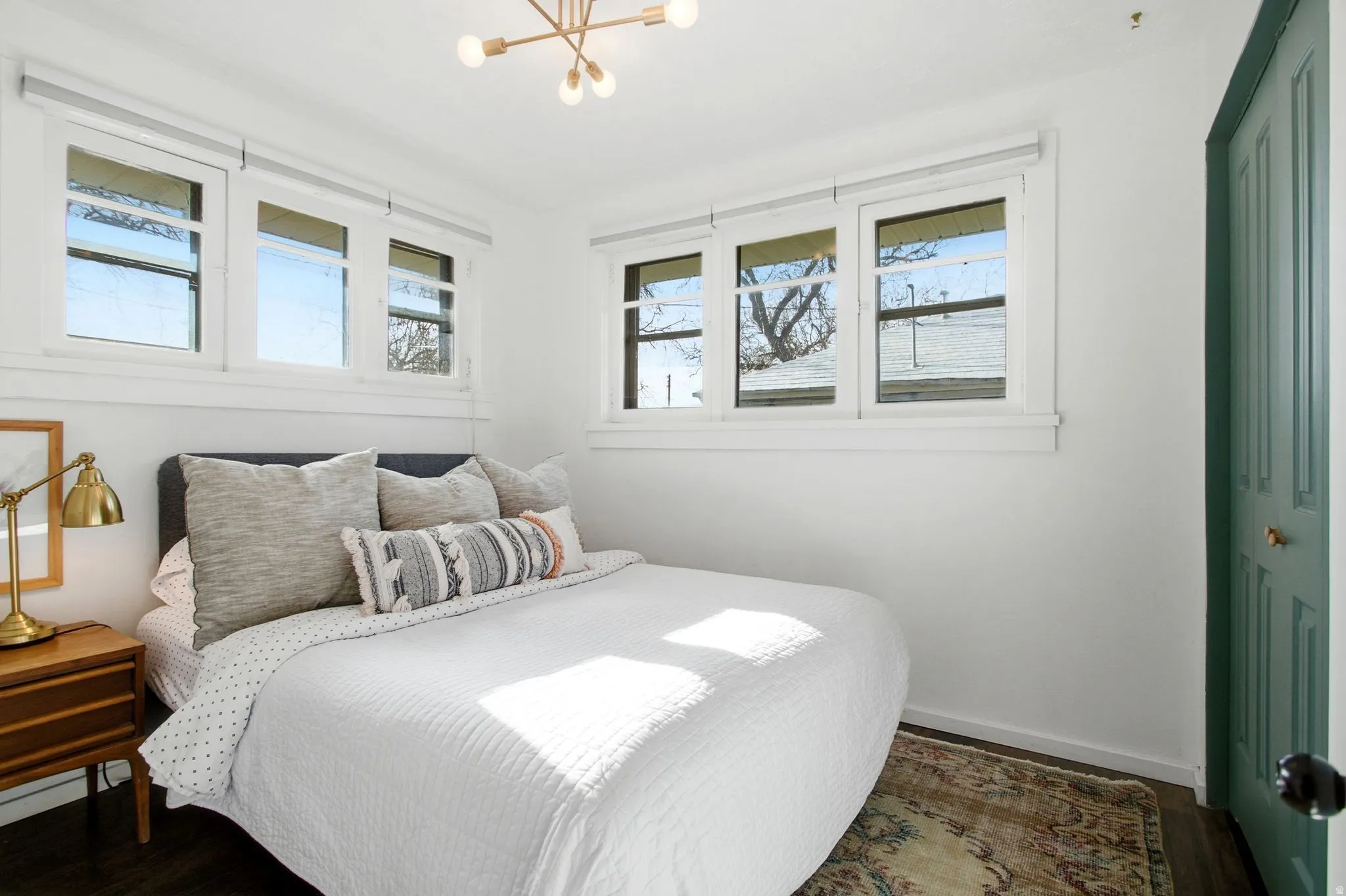 Bedroom with wood finished floors, a chandelier, and multiple windows