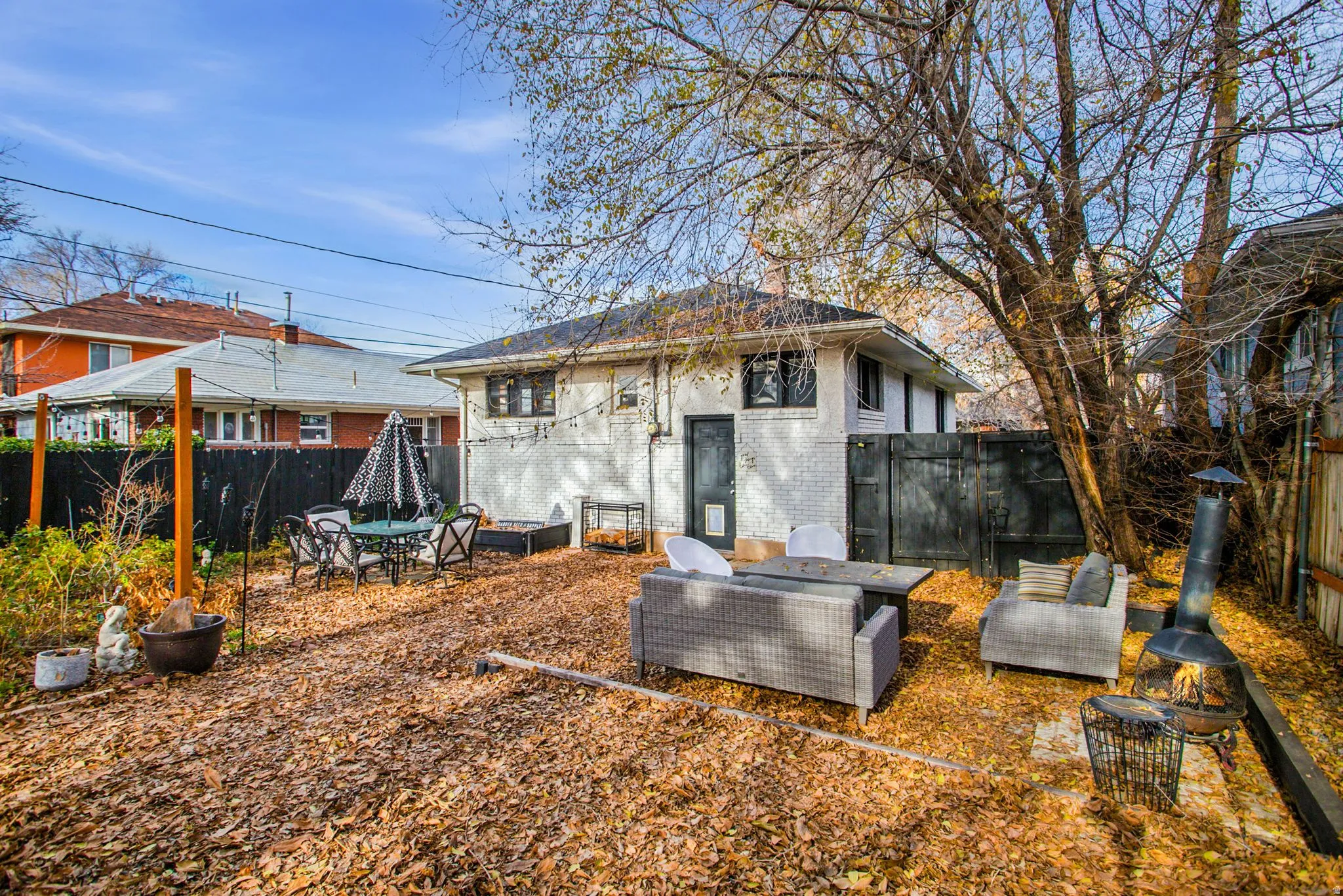 Rear view of property with brick siding, a fenced backyard, and a patio