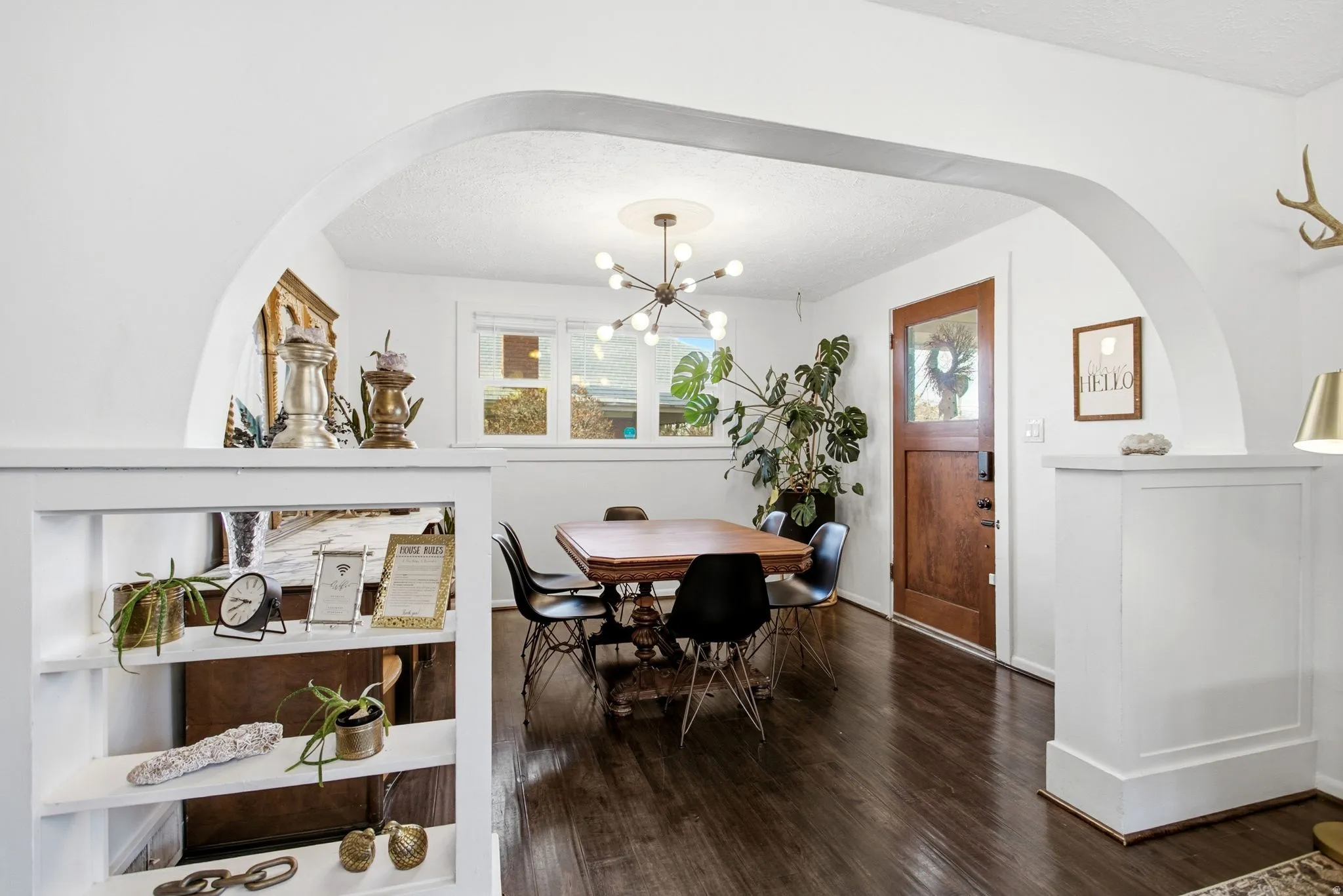 Dining area with arched walkways, dark wood finished floors, a textured ceiling, and a chandelier