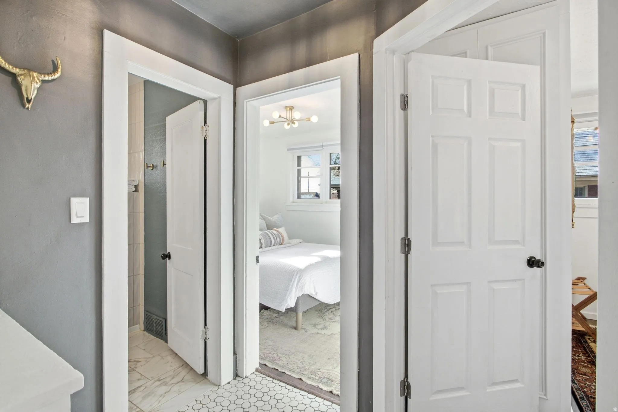 Corridor with a chandelier and light marble finish floors
