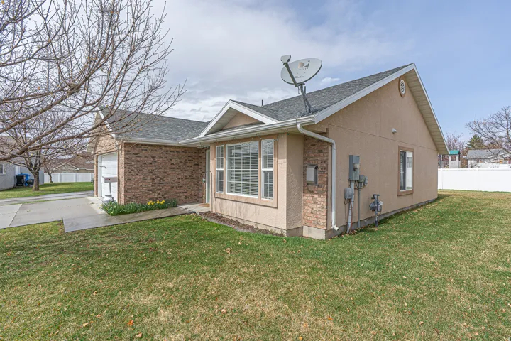 View of home's exterior with a shingled roof, stucco siding, driveway, and a garage