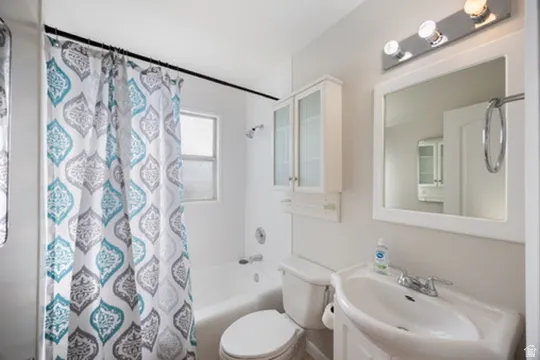 Full bathroom featuring shower / bath combo with shower curtain and vanity