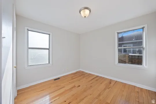 Spare room featuring light wood-style floors and baseboards