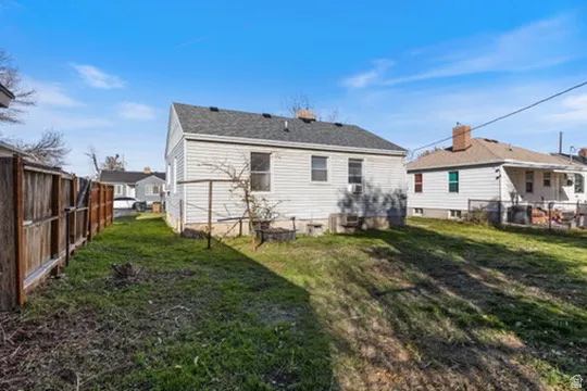 Rear view of house featuring a fenced backyard