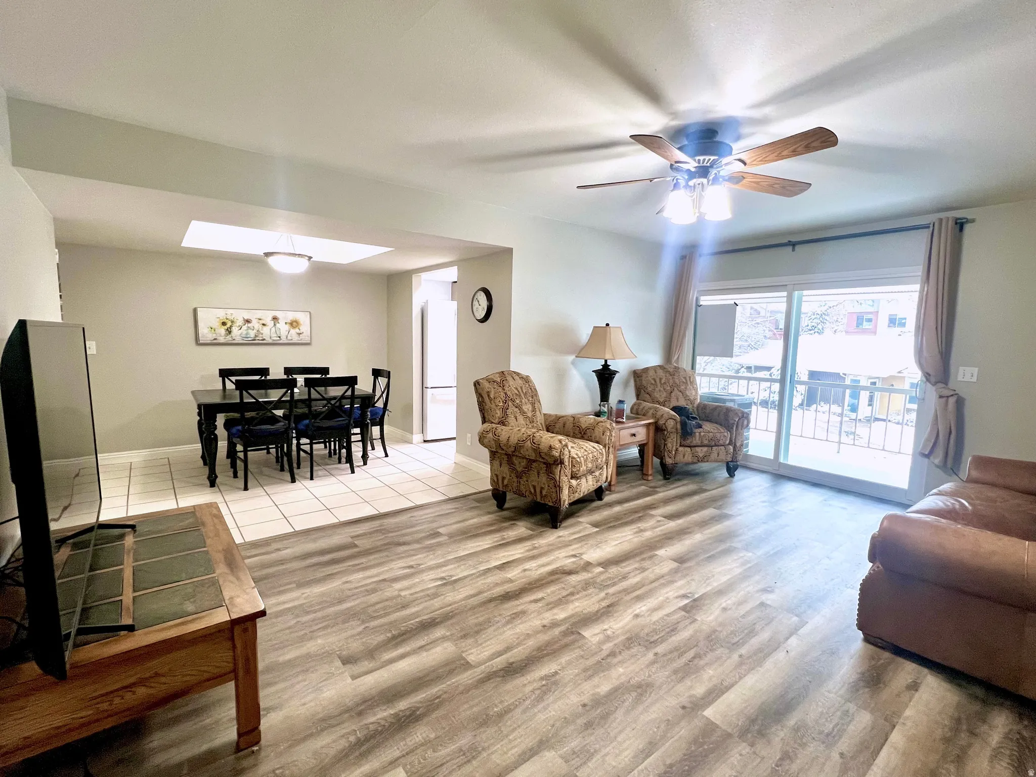 Living room featuring ceiling fan and light wood-style floors