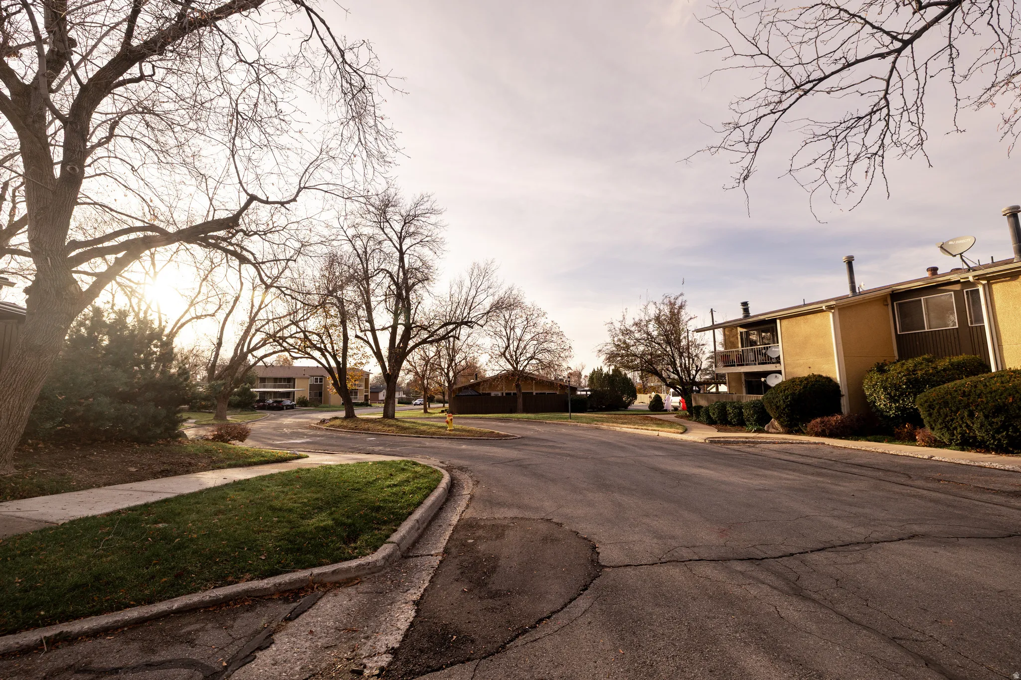 View of asphalt road featuring sidewalks, curbs, and a residential view