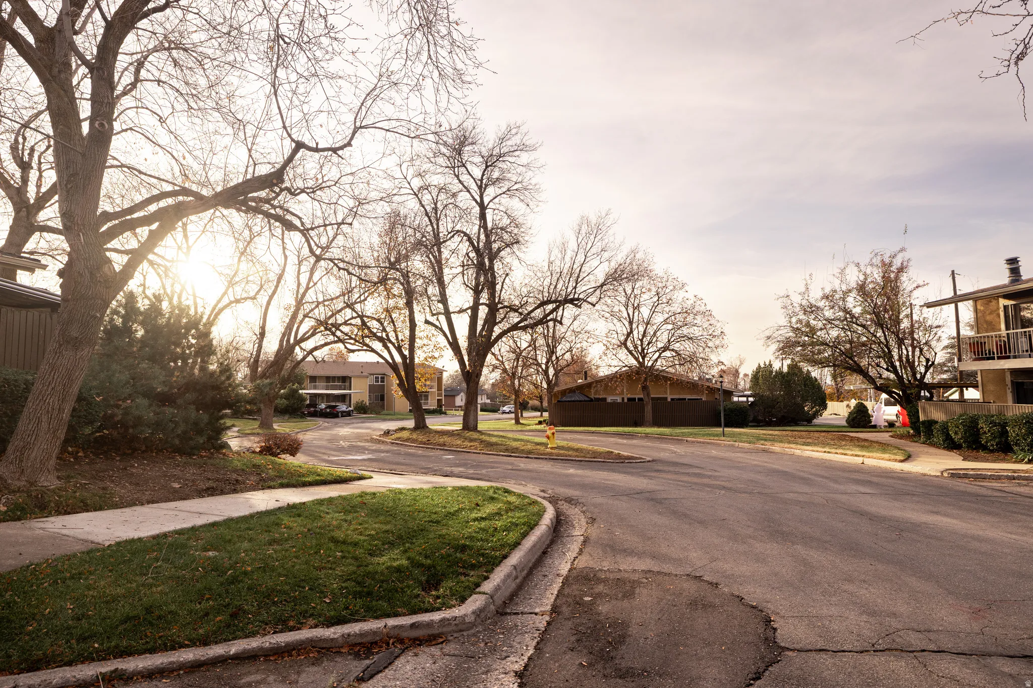 View of asphalt road featuring a residential view, sidewalks, and curbs