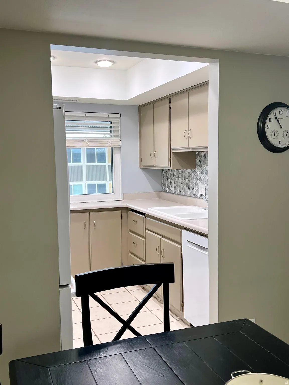 Kitchen featuring light countertops, white dishwasher, and tasteful backsplash