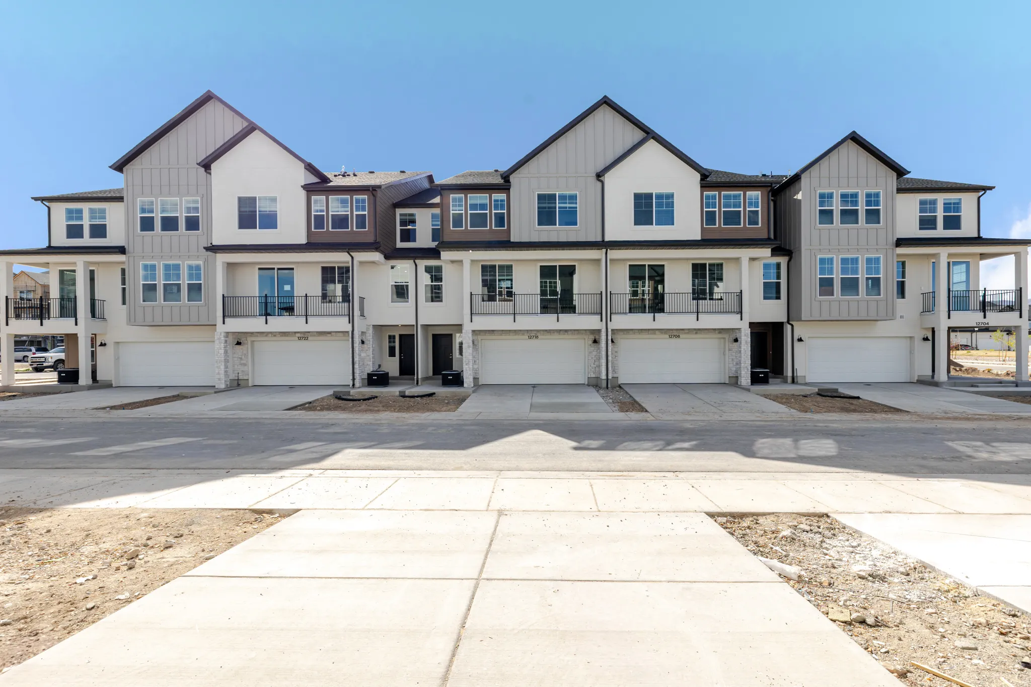 View of front facade with board and batten siding, a garage, a residential view, and concrete driveway