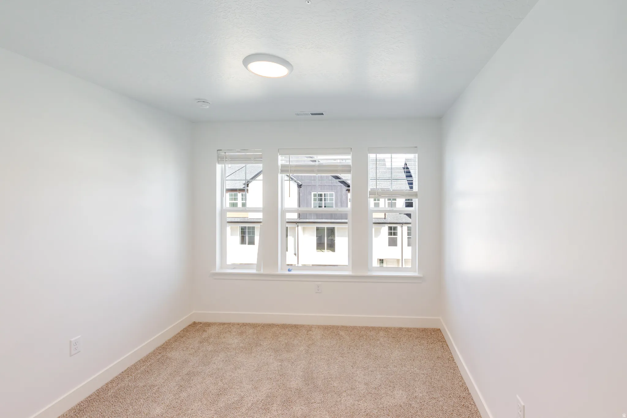 Unfurnished room with light carpet and healthy amount of natural light