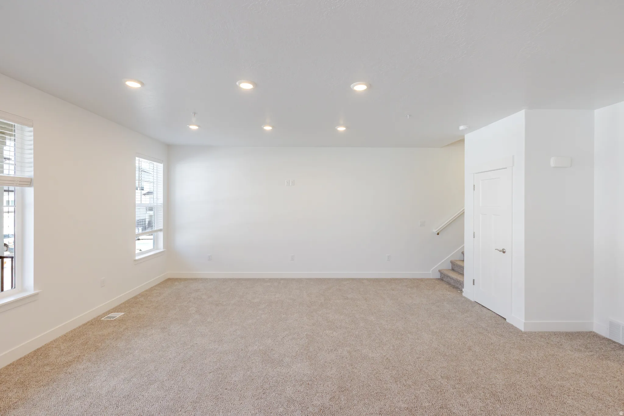 Empty room featuring light colored carpet and recessed lighting