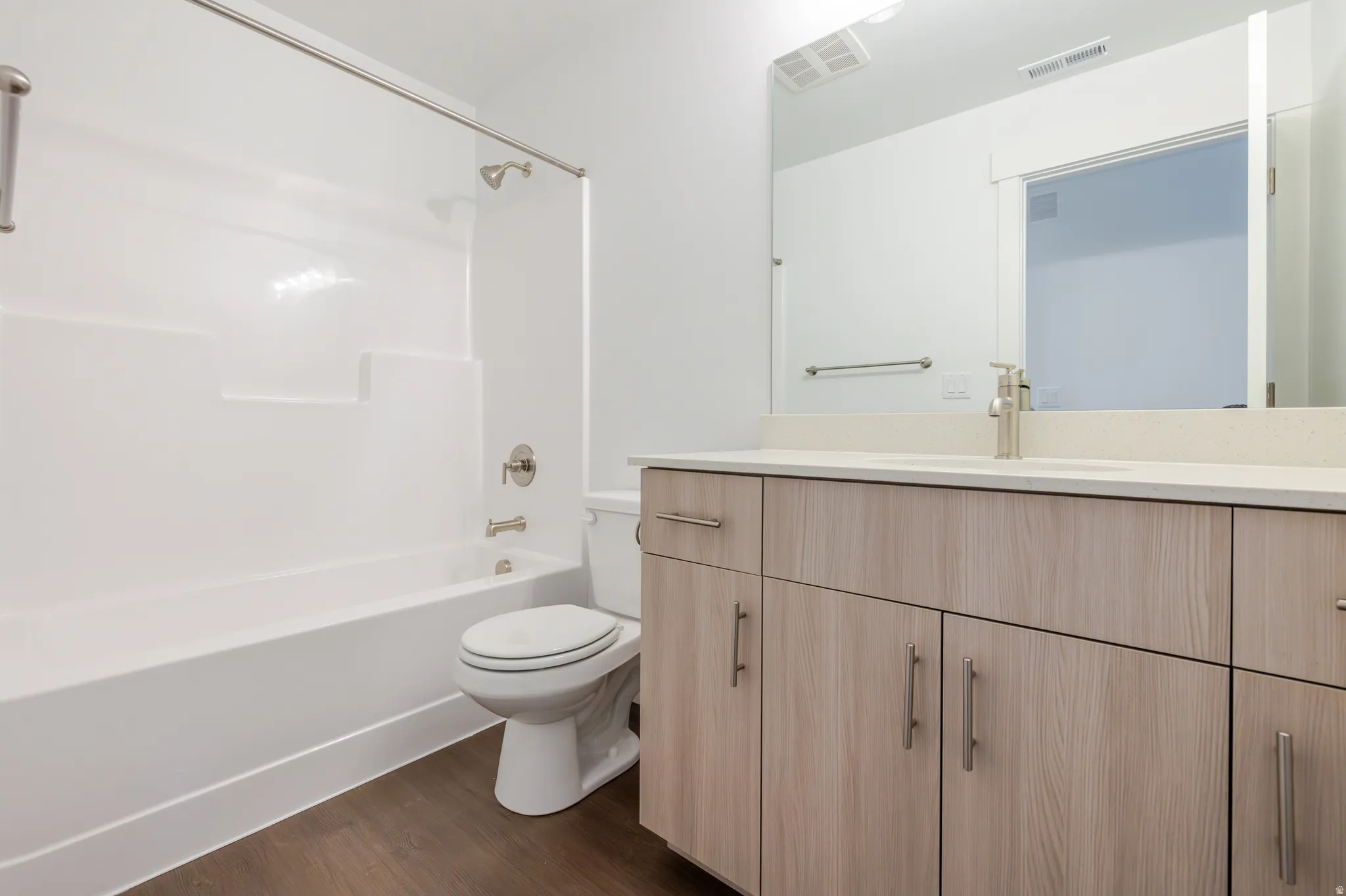 Full bath with vanity, shower / bathtub combination, and dark wood-style flooring