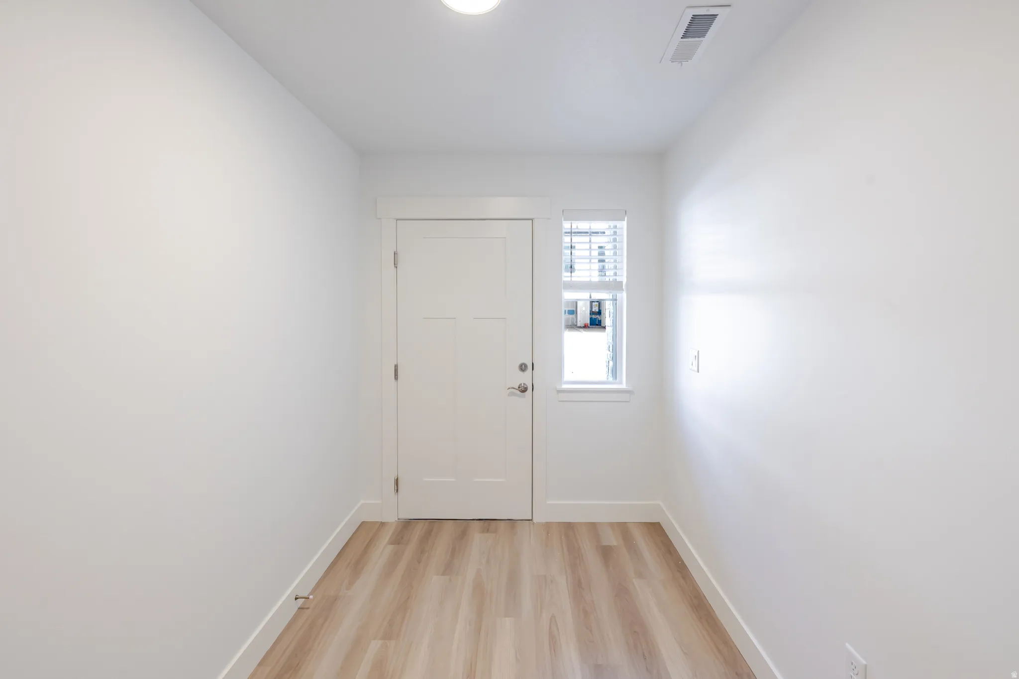 Doorway featuring wood finished floors and baseboards