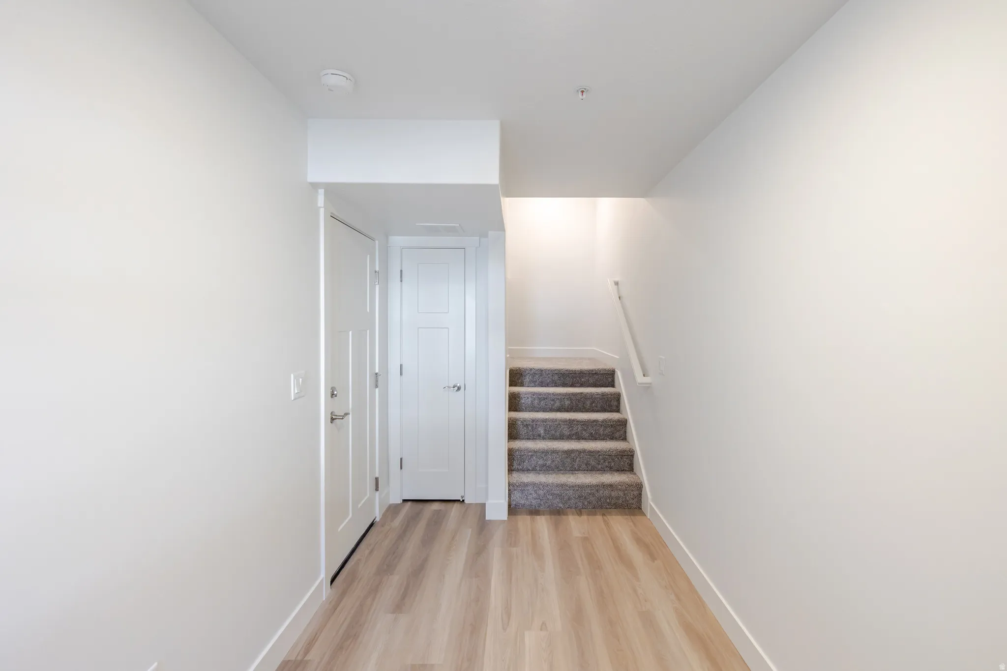 Staircase with wood finished floors and baseboards