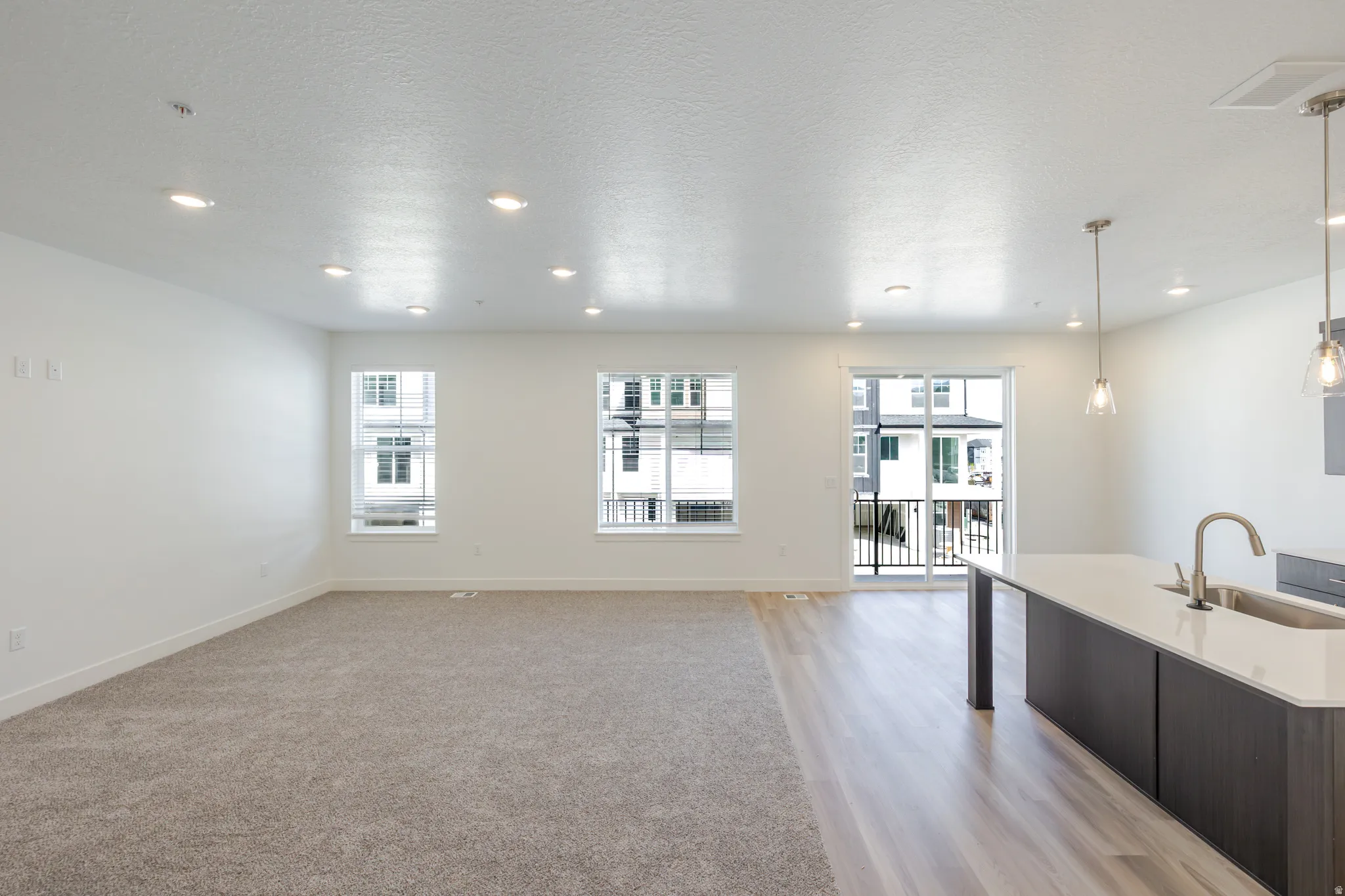 Unfurnished living room with a textured ceiling and recessed lighting