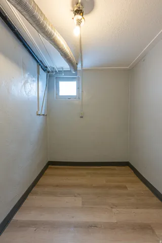 Spare room featuring light wood-style floors, a textured ceiling, and a textured wall