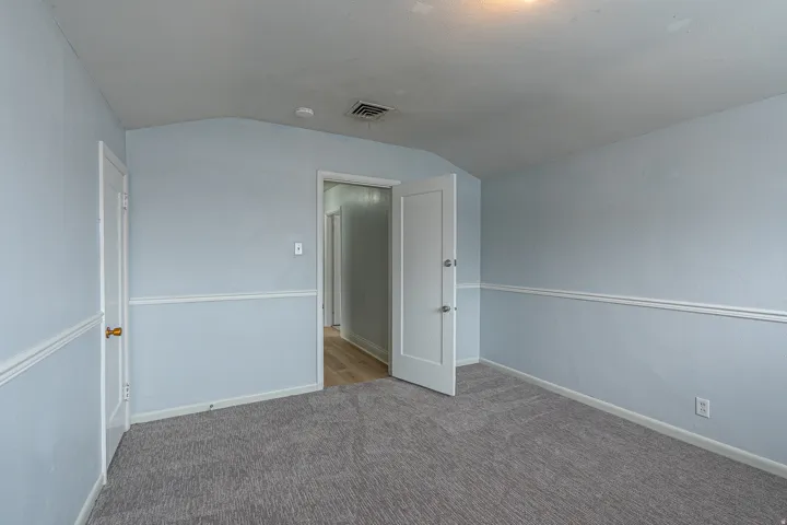 Spare room featuring lofted ceiling and carpet floors
