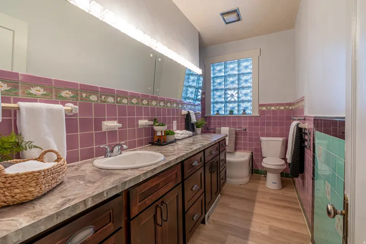 Bathroom with vanity, wainscoting, tile walls, and light wood-type flooring