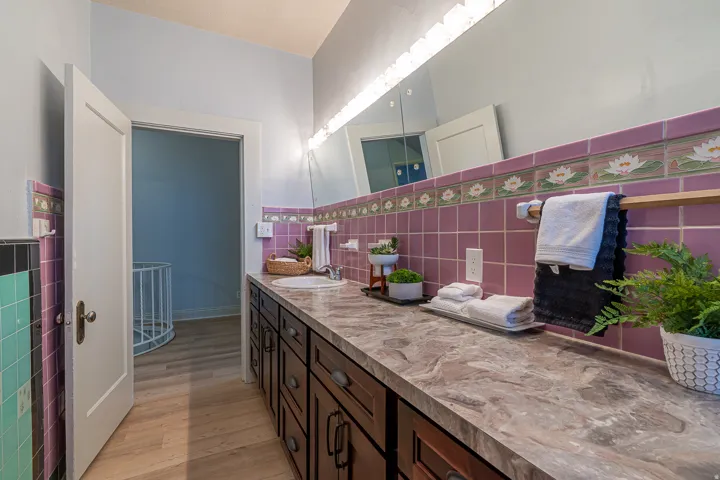 Bathroom with vanity, light wood-style flooring, and tile walls