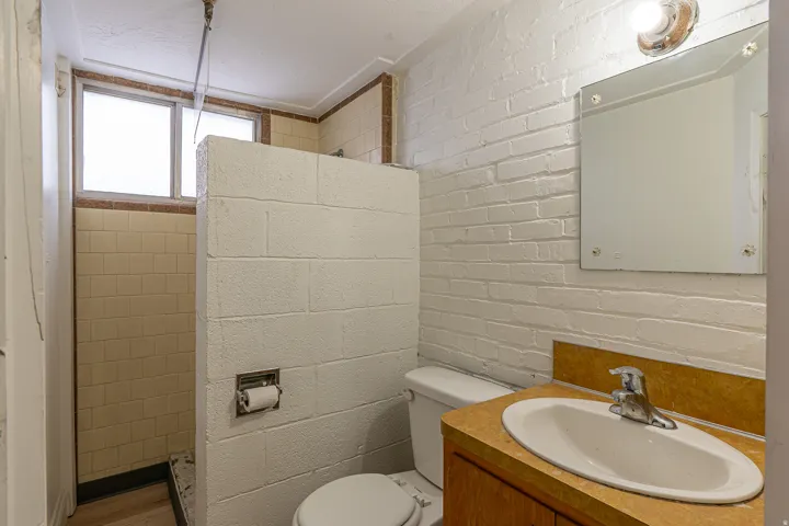 Bathroom with vanity and brick wall