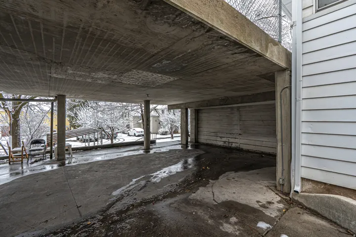 Snow covered patio featuring a garage