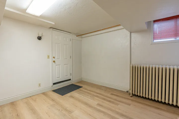 Spare room featuring radiator heating unit, a textured ceiling, and light wood-style flooring