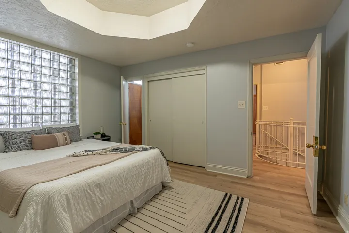 Bedroom with a closet, light wood-type flooring, and a textured ceiling