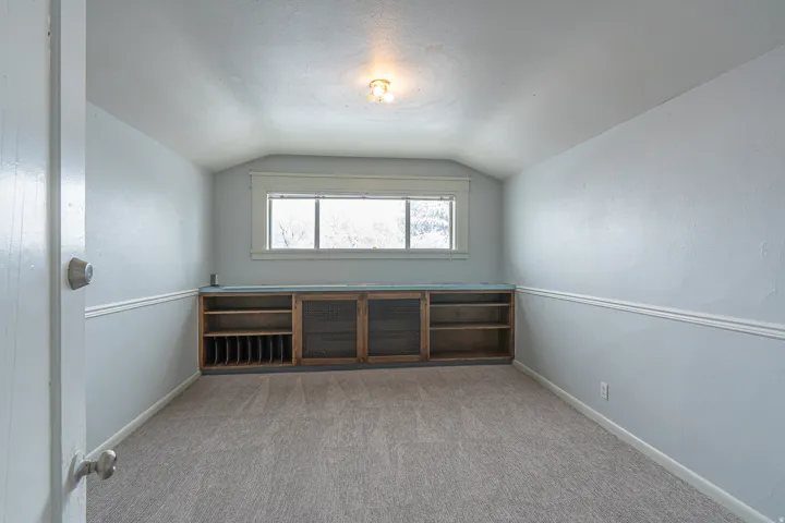 Bonus room featuring lofted ceiling, a textured ceiling, and light colored carpet