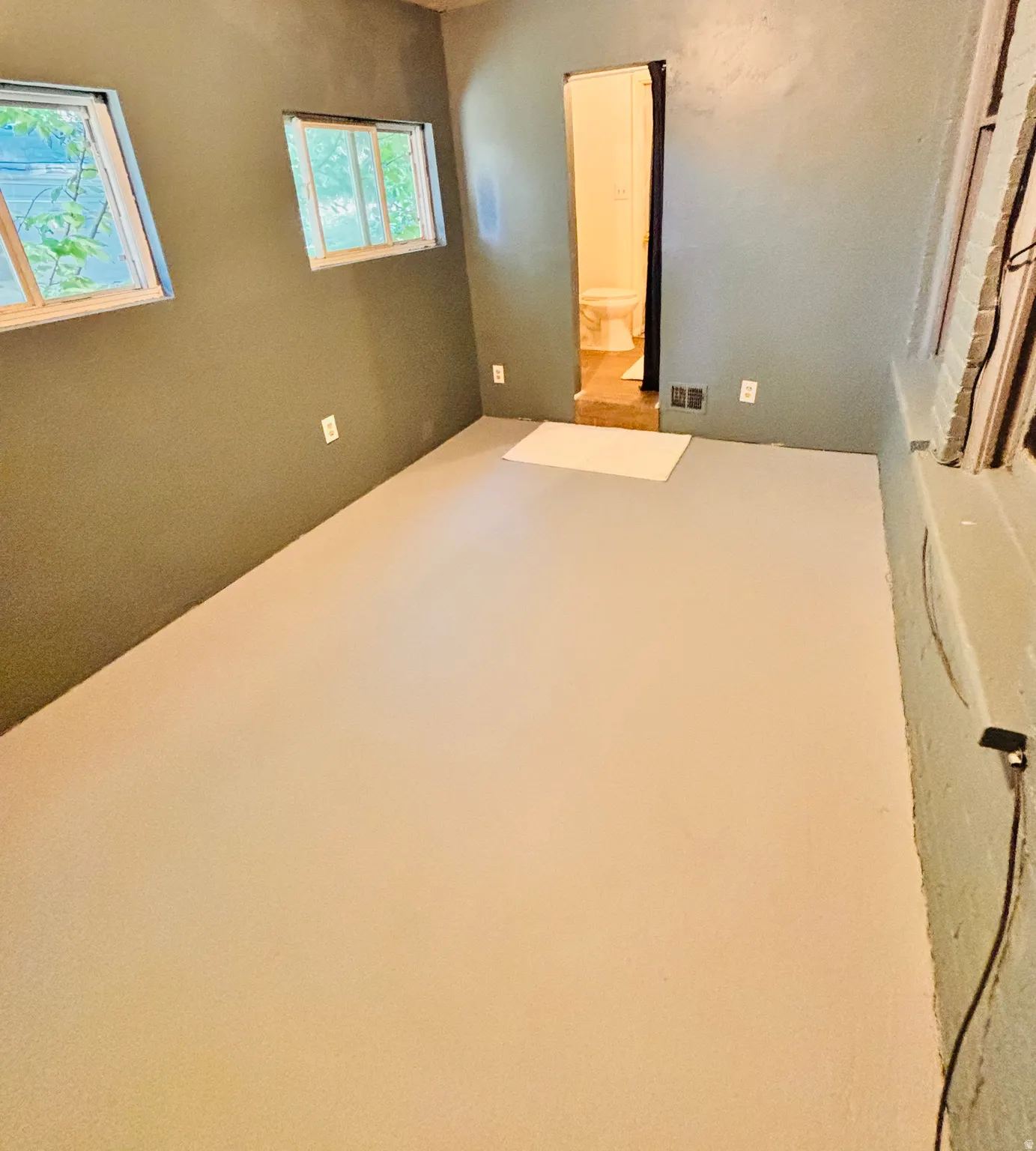 Neutral wall finishes, light-toned flooring, and multiple window openings
