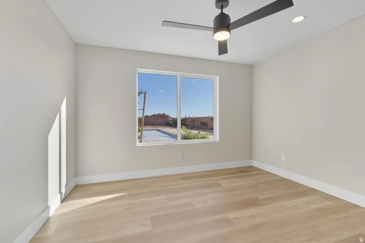 Empty room featuring light wood-style floors, a ceiling fan, and recessed lighting