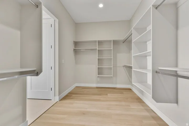 Walk in closet with light wood-style flooring