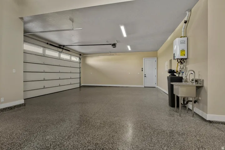 Garage featuring baseboards and water heater