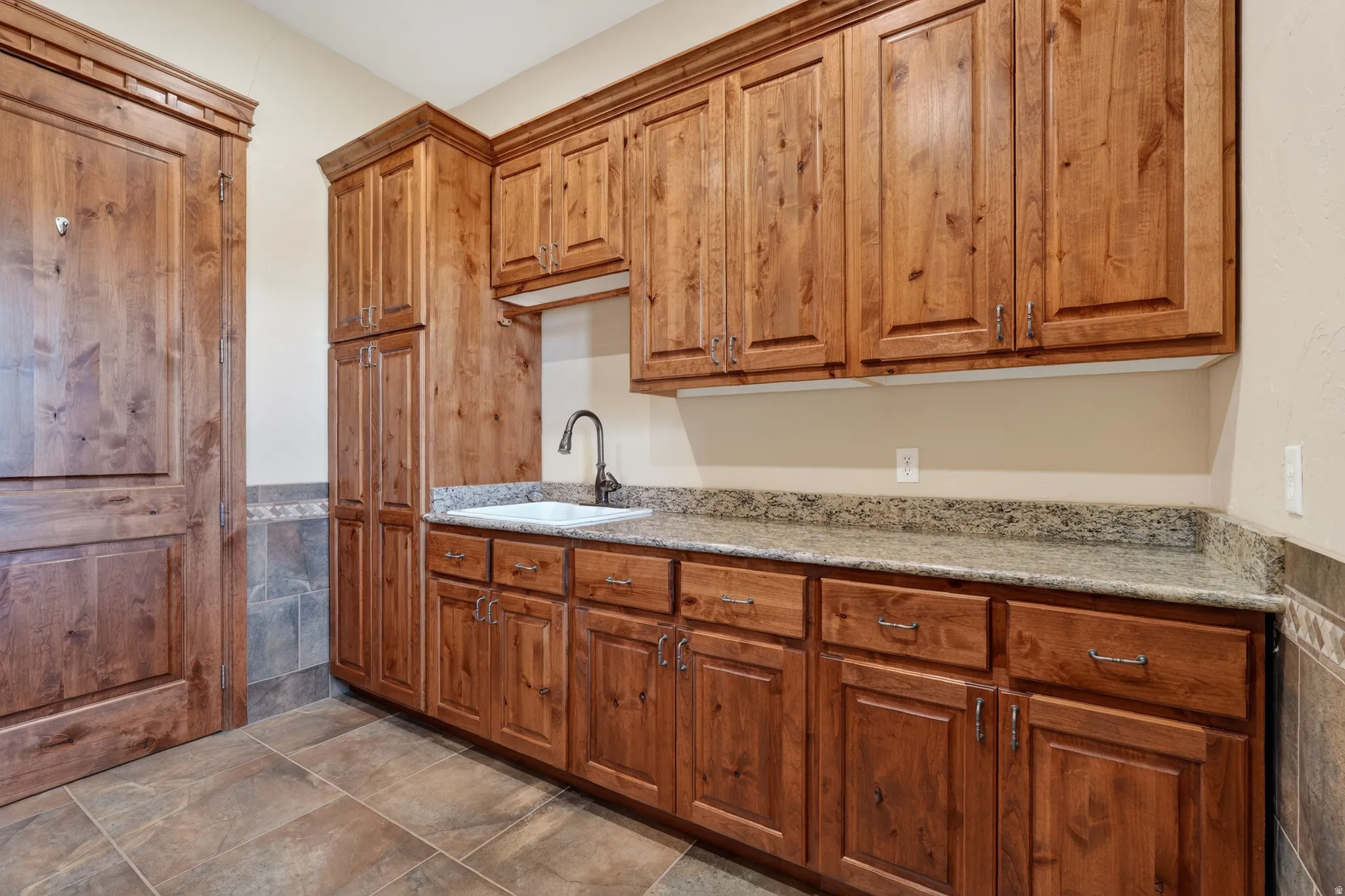 Kitchen featuring light stone countertops and brown cabinets