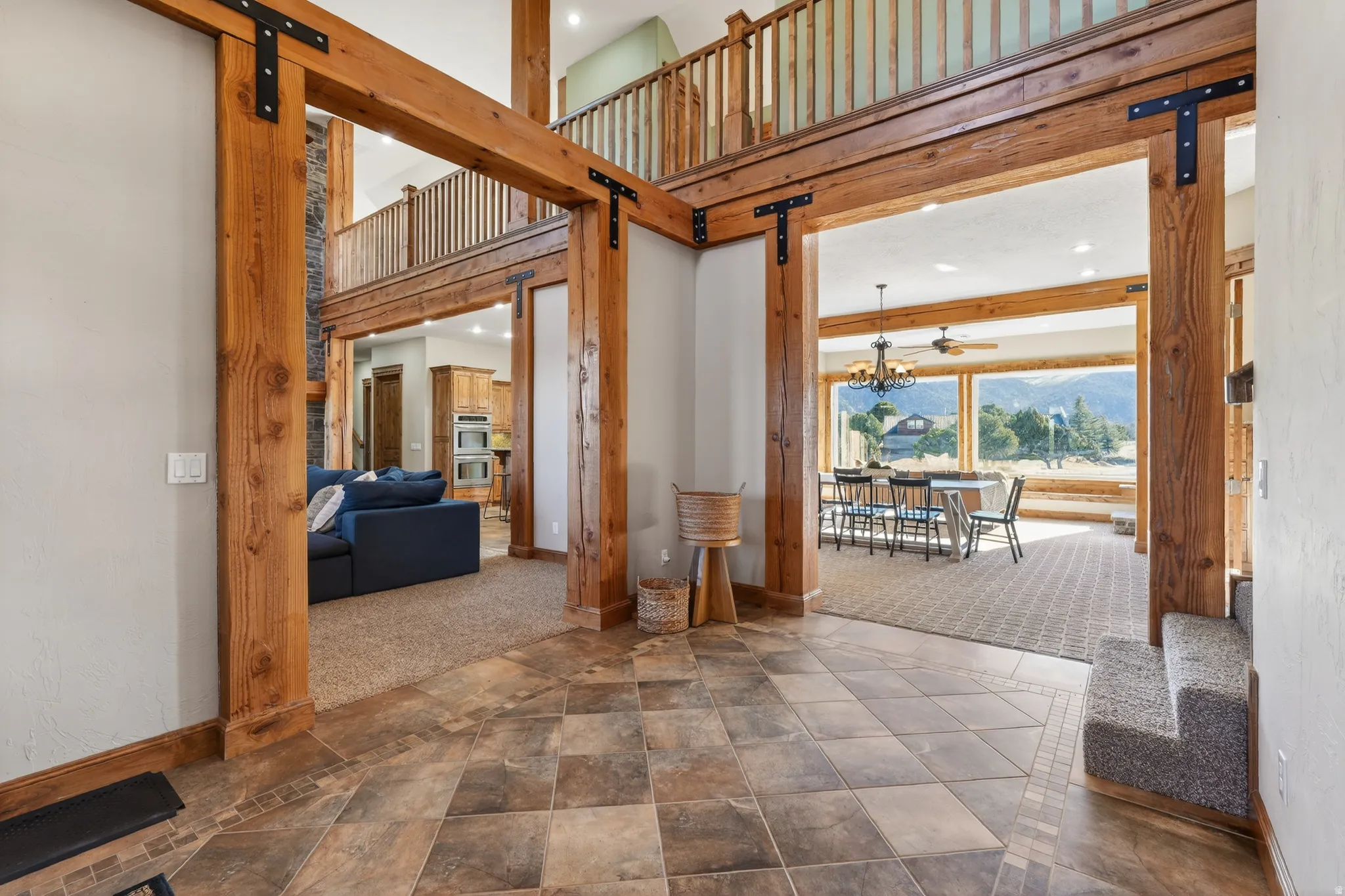 Hall featuring a barn door, carpet flooring, a high ceiling, stone finish flooring, and recessed lighting