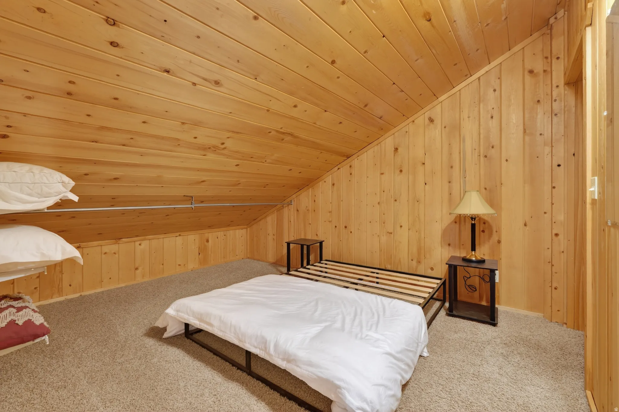 Bedroom featuring wooden ceiling, lofted ceiling, light colored carpet, and wooden walls