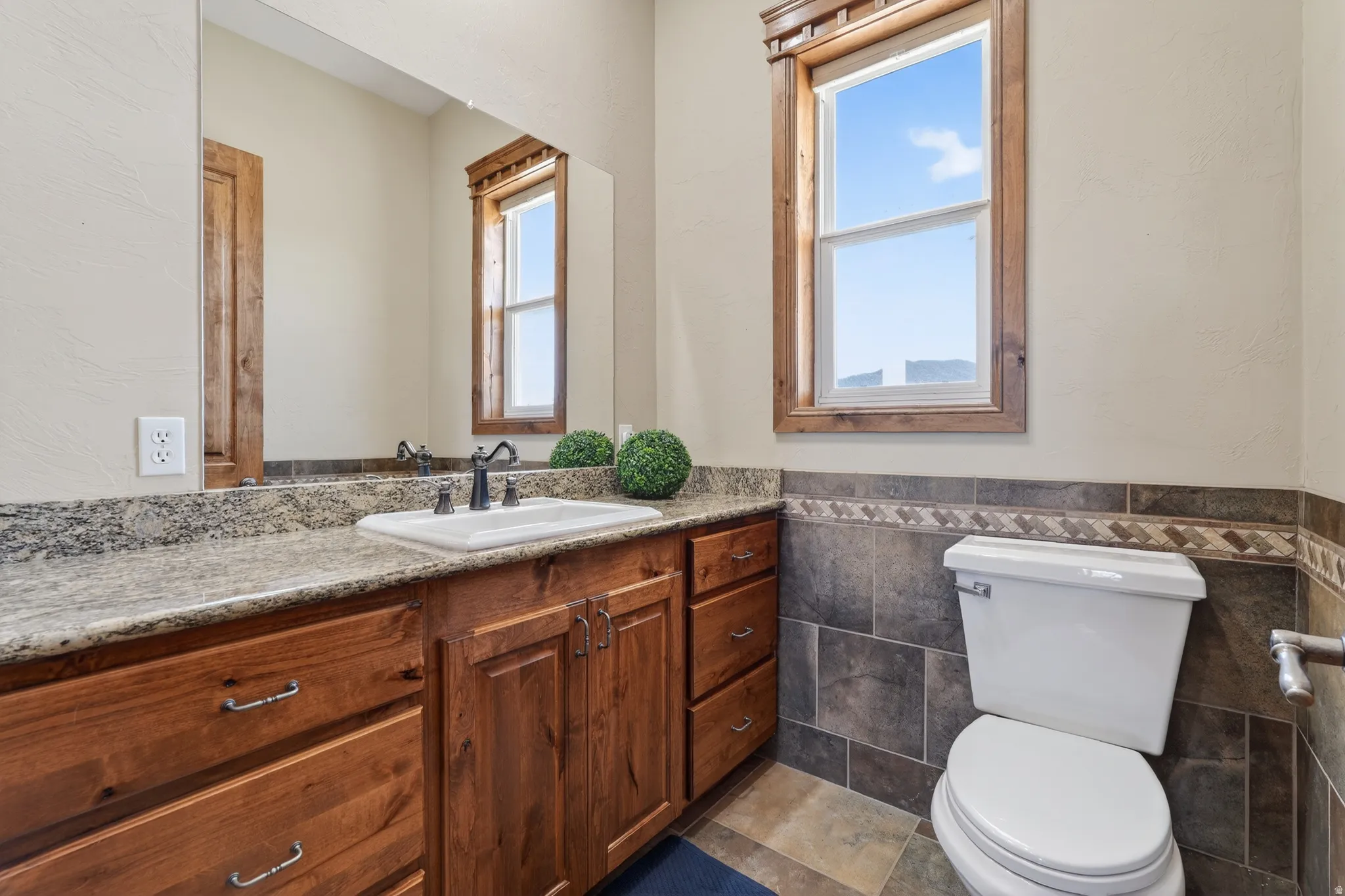 Bathroom with vanity, wainscoting, and tile walls
