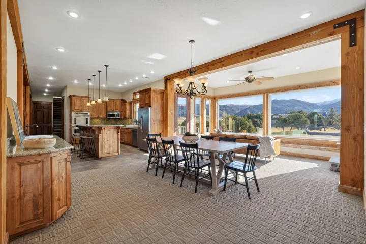 Dining area with a chandelier, a mountain view, light carpet, a ceiling fan, and recessed lighting