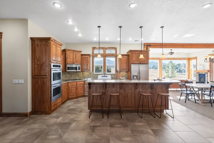 Kitchen featuring brown cabinets, hanging light fixtures, a kitchen breakfast bar, a center island, and recessed lighting