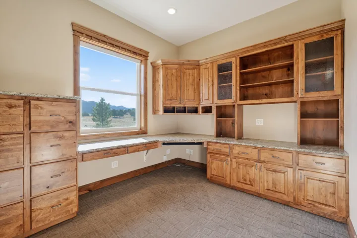 Unfurnished office featuring built in desk and brick patterned floors